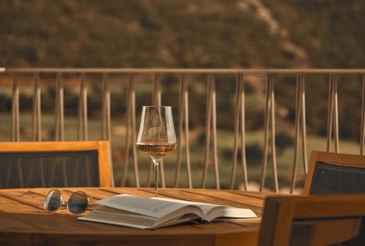 A patio table with a glass of white wine on top at Viceroy Ombria Algarve