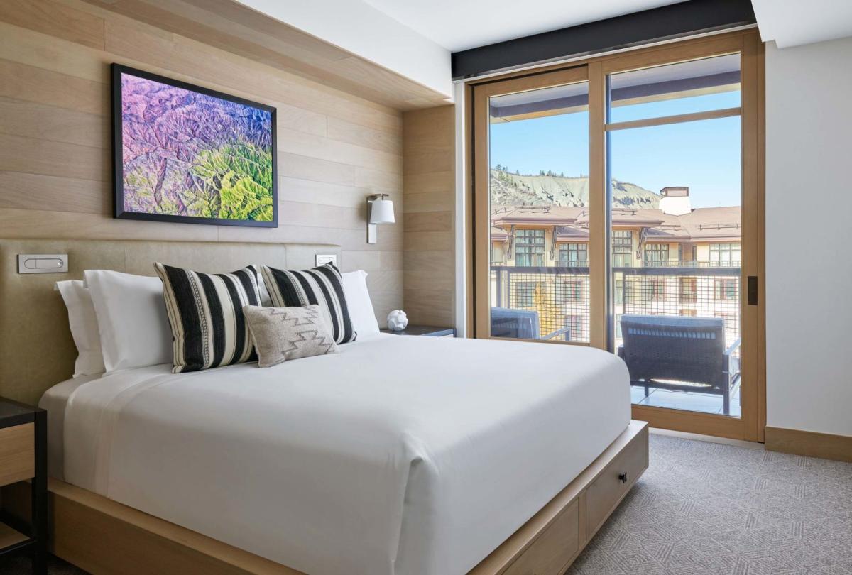 A large King bed looking out on a mountain village