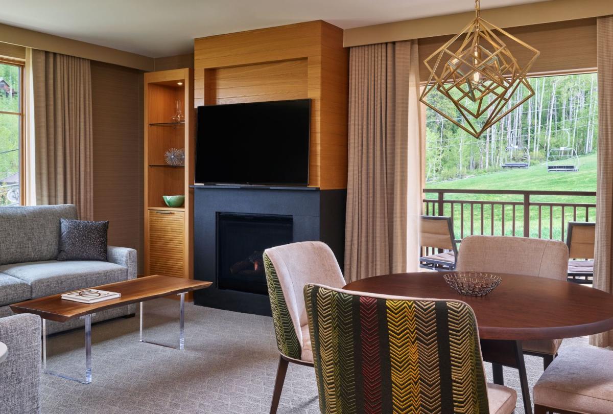 The dining and living room with a fireplace in a pinnacle two bedroom residence at Viceroy Snowmass