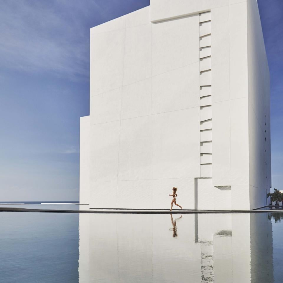 person runs alongside the pool