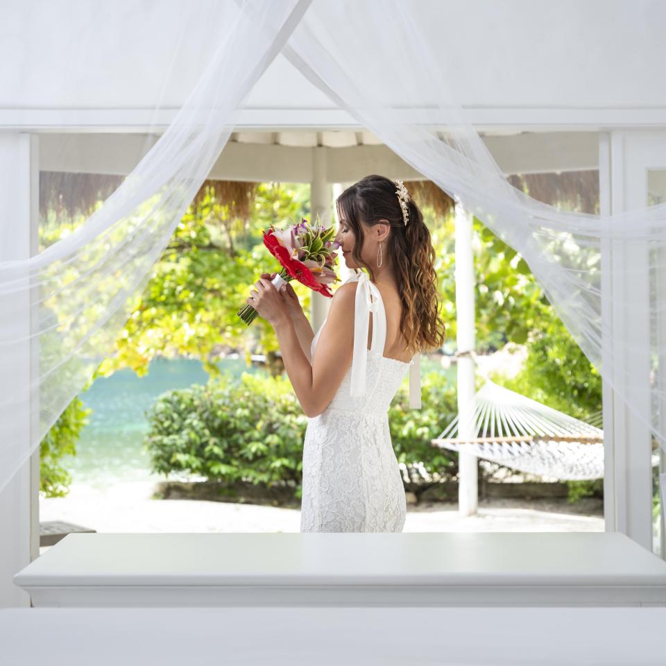 bride holds a red floral arrangement