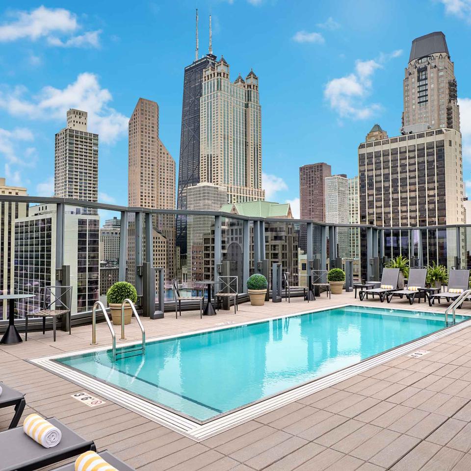 An outdoor rooftop pool at Viceroy Chicago, with high-rise architecture in the background