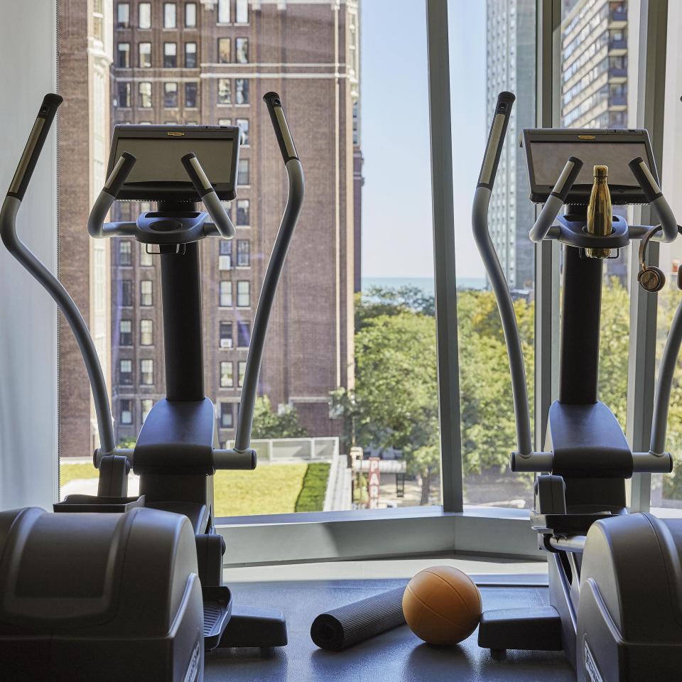 Two Elliptical exercise machines in front of a window with a view of the Chicago skyline