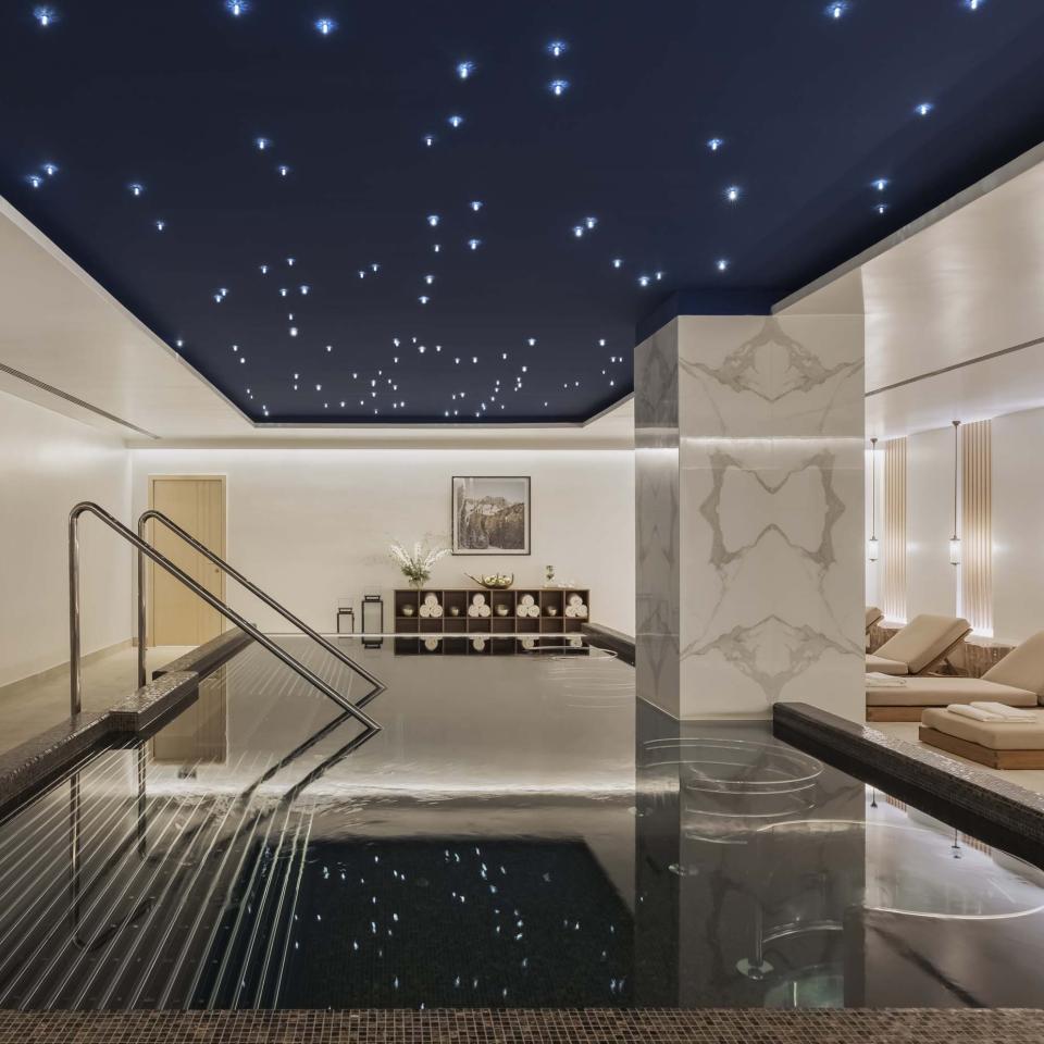 The spa at Viceroy Kopaonik Serbia, with a wading pool and recliners under a ceiling painted like a starry sky