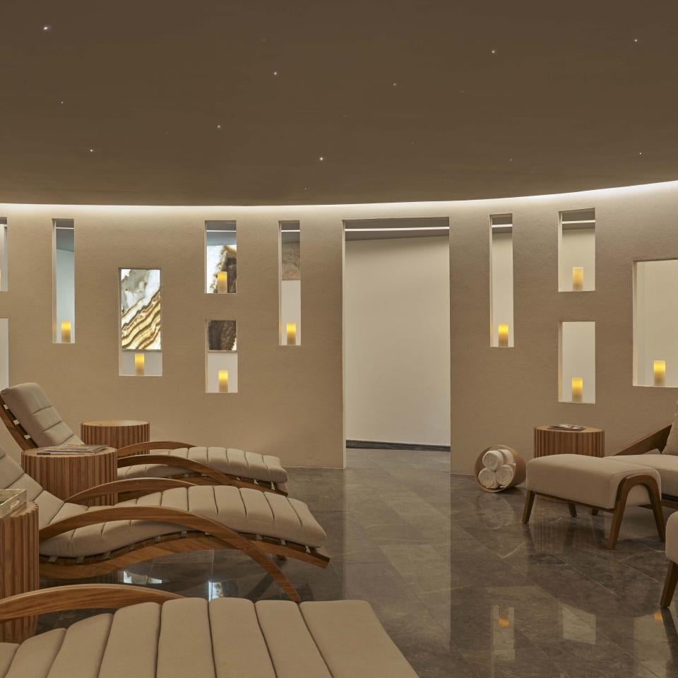 A relaxation room with comfortable recliners, lit by candle light, at the Viceroy Los Cabos spa