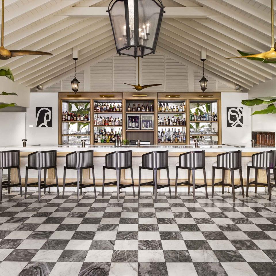 The Saltwood Bar at Sugar Beach, with a row of wood bar stools and a checkerboard floor