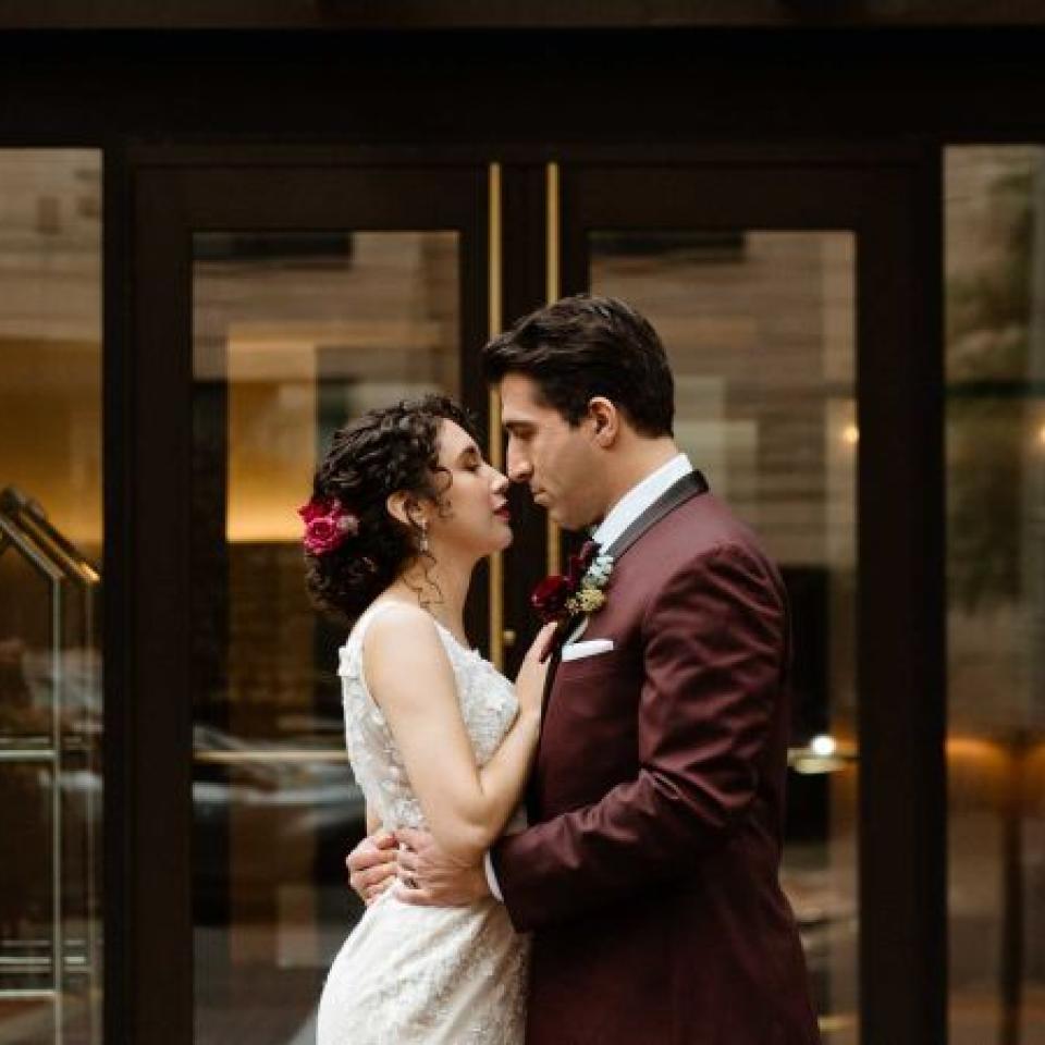 A couple in wedding garb cuddles in front of Viceroy Washington DC