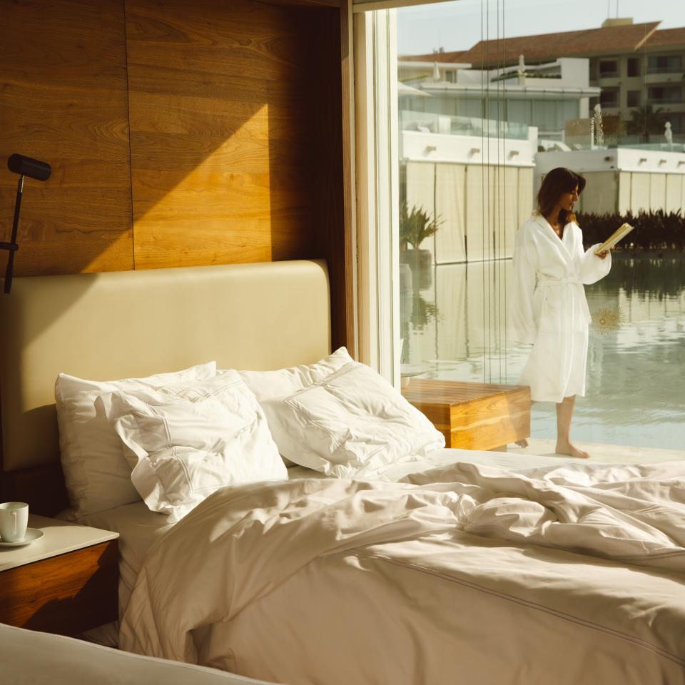 Mulher à porta do quarto de uma villa à beira-mar