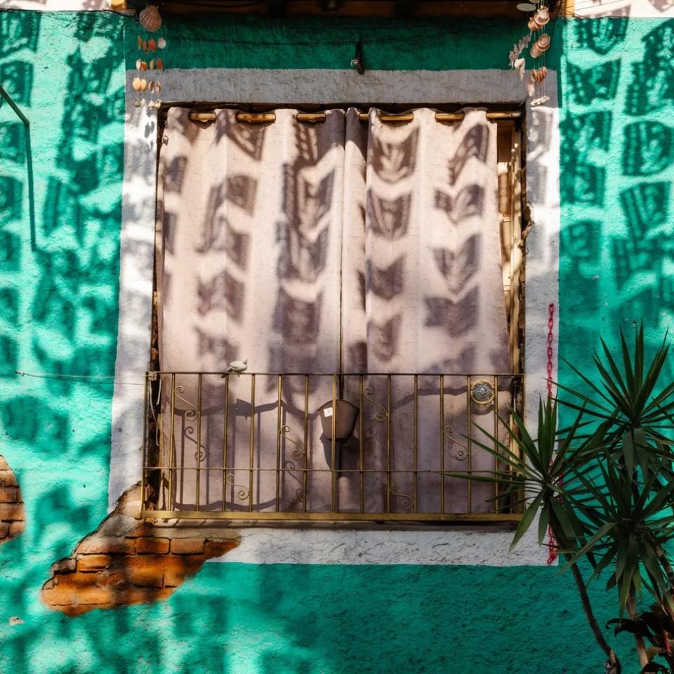 A window on a colorful building in Los Cabos