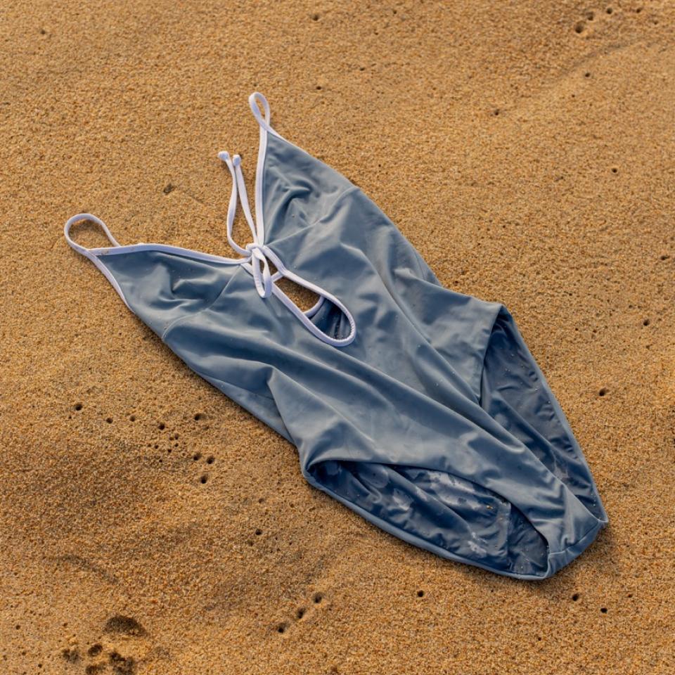 A one piece bathing suit on the beach.