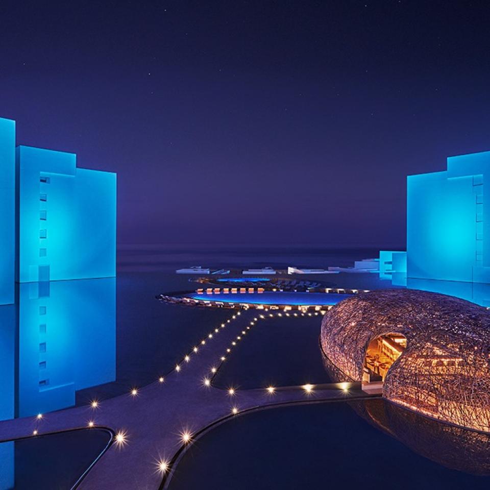 night view of a hotel surrounded by water