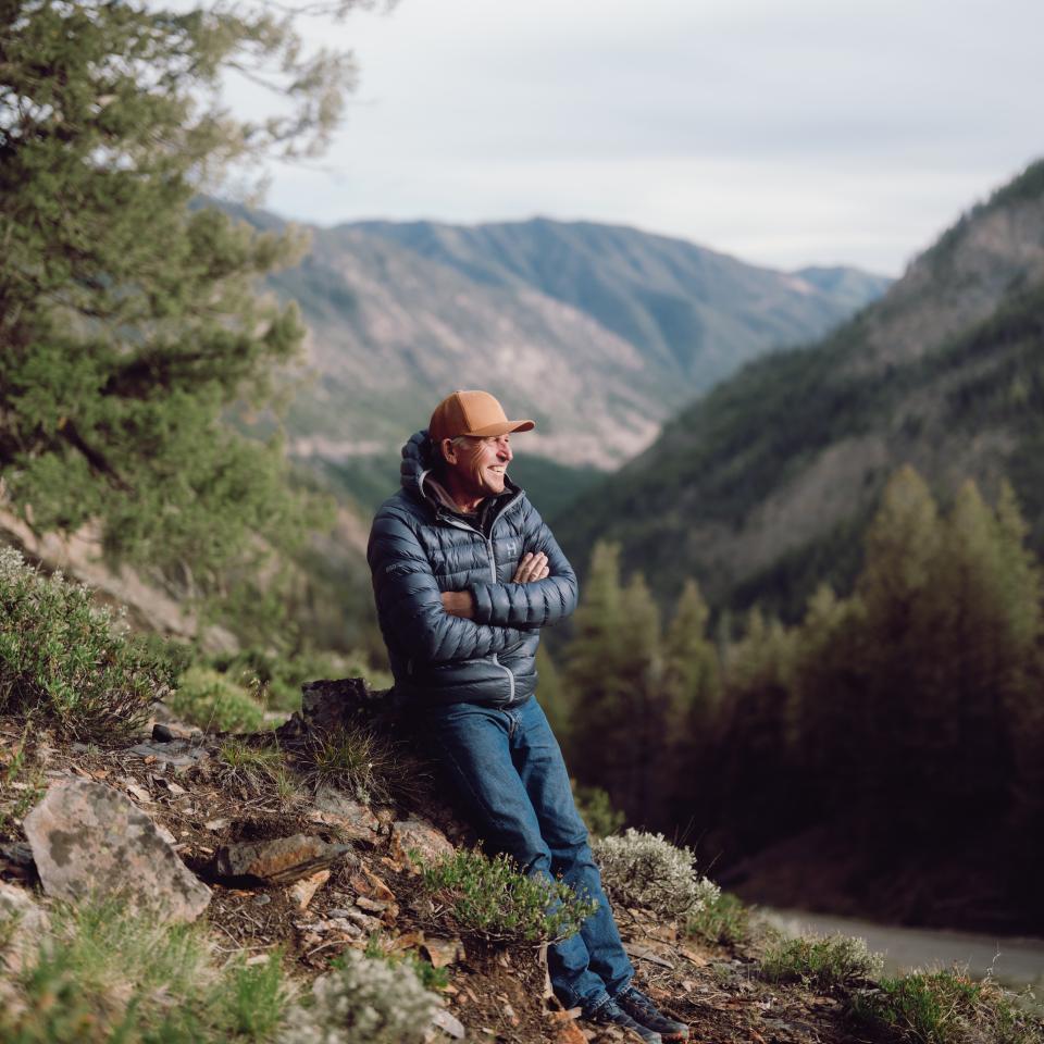 Mountaineer Ed Viesturs resting against a stump in a Sun Valley mountain range