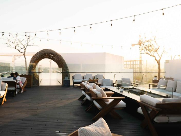exterior deck with seating, lighting, and archway
