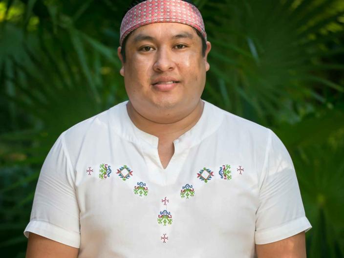 man wearing a white shirt and red bandana