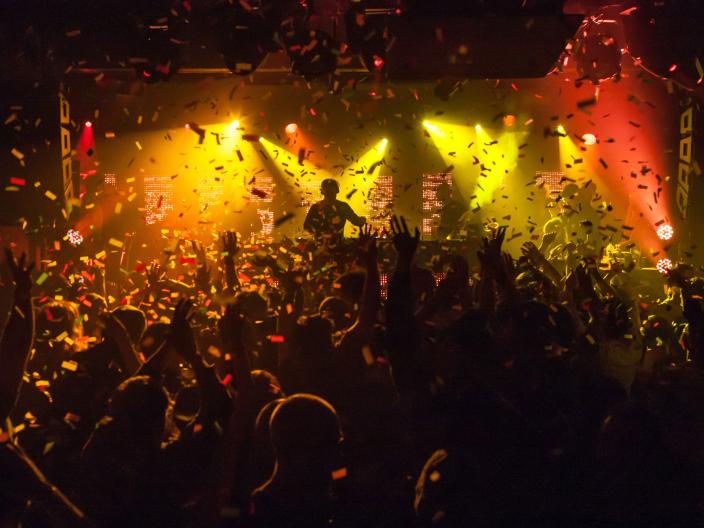 shadow of crowd in front of lit up performer on stage