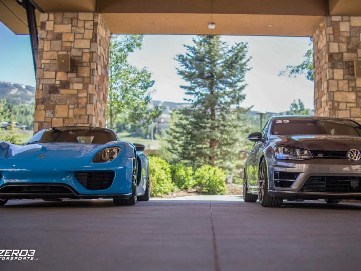 two luxury vehicles parked at hotel entrance