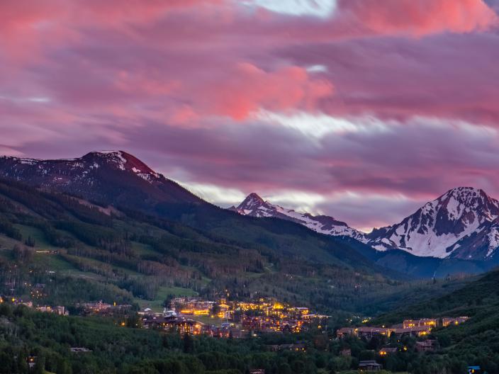 mountains in background with pink sky above the city below