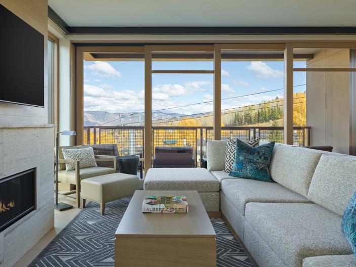 interior view of living room with tv, fireplace, and balcony