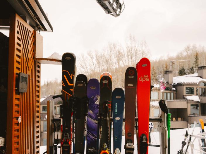 group of skis lean against pole