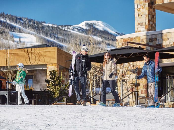 group of skiers walk near a building