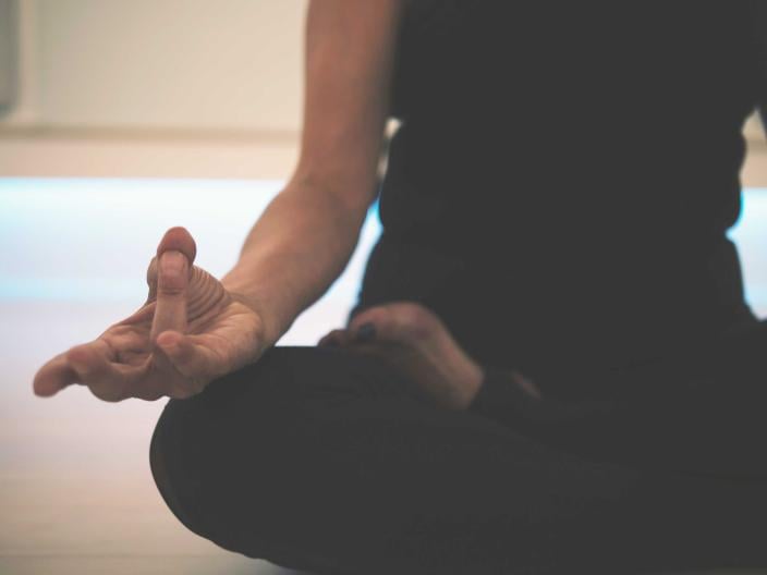 person sits in seated yoga pose