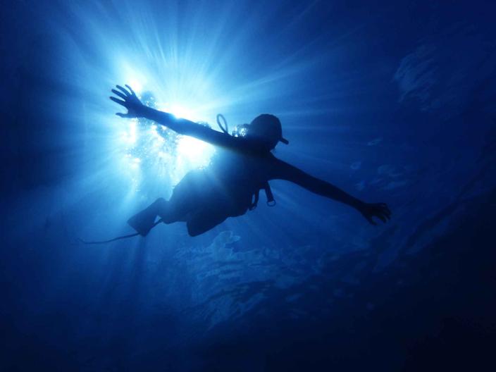 shadow of person in scuba gear under water
