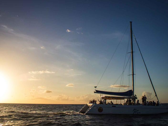 outline of sailboat with sunsetting in background