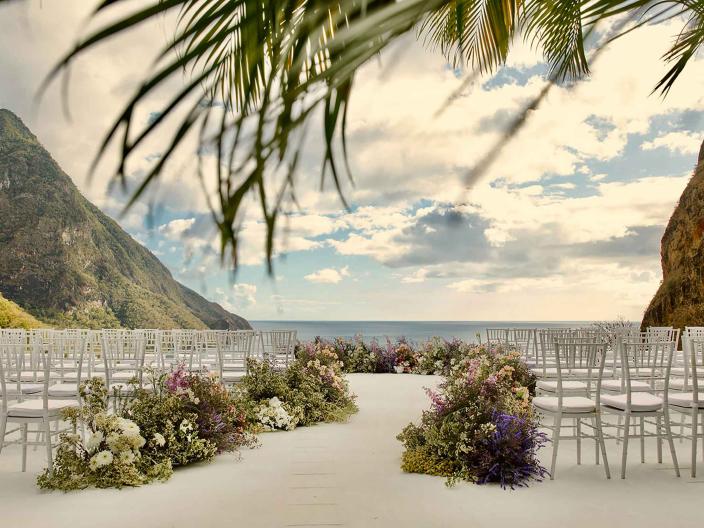 chairs set up in rows with floral arrangements placed on aisle for wedding