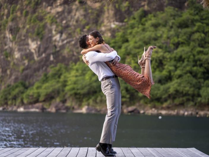couple embraces near the water