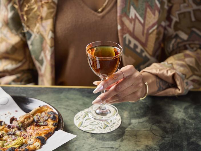 A woman holding a glass of whiskey