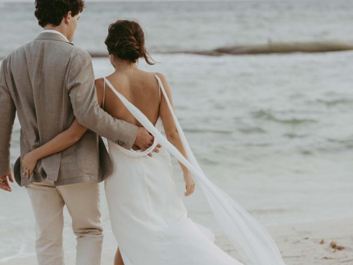 Bride and groom walking on the beach