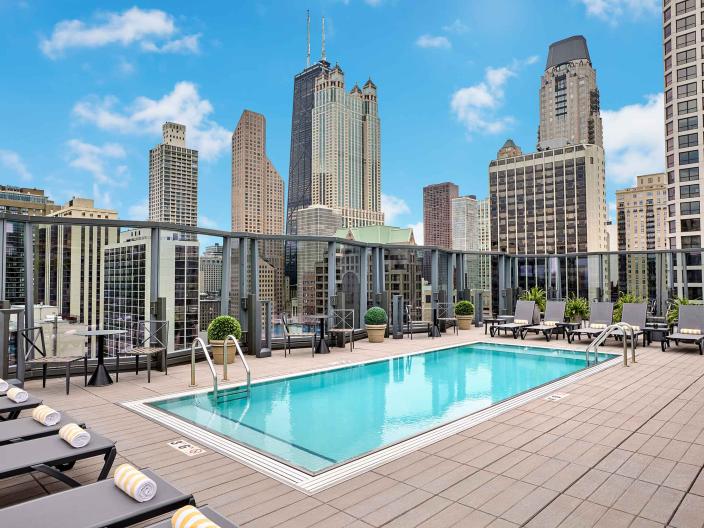An outdoor rooftop pool at Viceroy Chicago, with high-rise architecture in the background