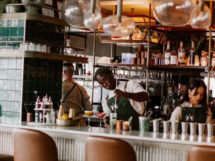 A bartender stirs a drink at the bar of Pandan restaurant
