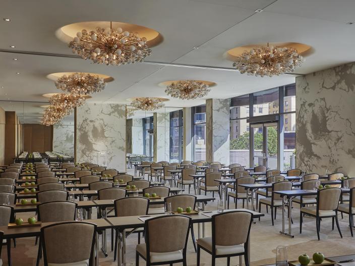 A long meeting room with rows of desk under a set of ornate pendant lights at Viceroy Chicago