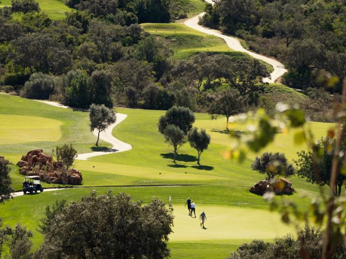 Three men walking on a golf green at Viceroy Ombria Algarve