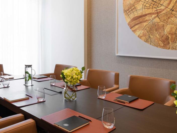 The Sky Boardroom at Viceroy Kopaonik Serbia, with office chairs surrounding a long meeting table and a large art piece on the wall
