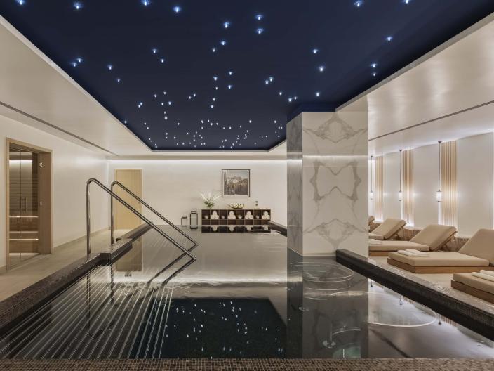 The spa at Viceroy Kopaonik Serbia, with a wading pool and recliners under a ceiling painted like a starry sky