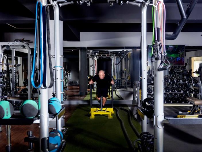 A man pushing a weight sled in the Los Cabos gym