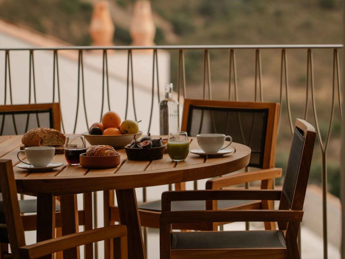 A round tablewith a spread of ordered in dishes on a balcony at Ombria Algarve