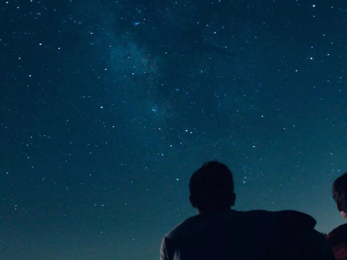 Duas pessoas a contemplar as estrelas à noite, perto de Ombria Algarve