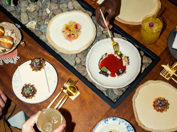 A spread of dishes to a customer at a restaurant at Ombria Algarve