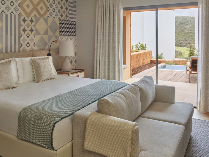 A king bed ina room with a couch, dresser, and a patio at Ombria Algarve