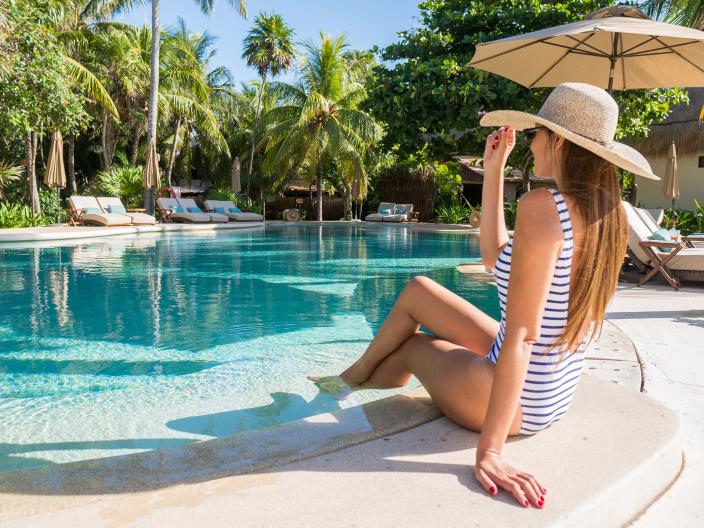 A woman lounging pool side at Riviera Maya