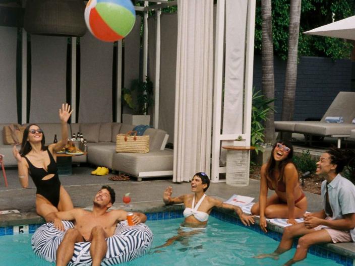 Guests at the Viceroy Santa Monica pool, dipping their toes in the water and passing around a beach ball