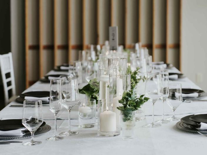 A table setting for a wedding at Viceroy Snowmass, with a white table cloth and leafy green centerpieces