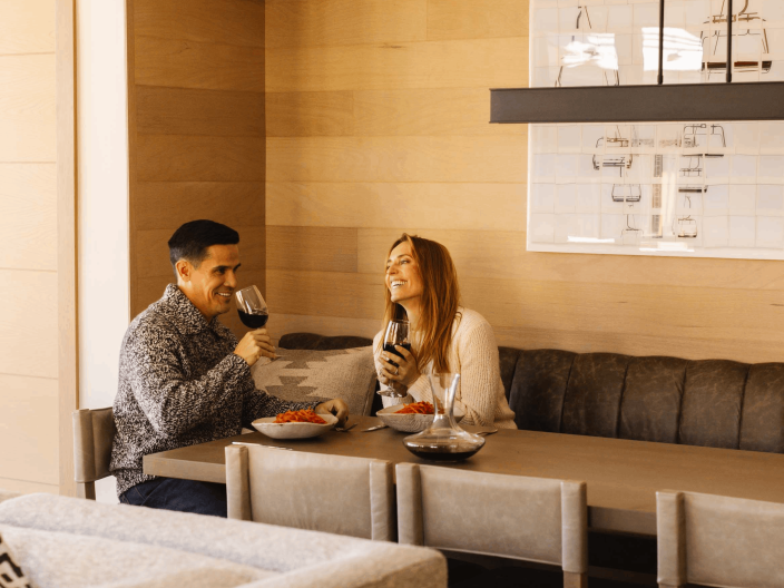 A couple laughing, eating and drinking wine at Viceroy Snowmass