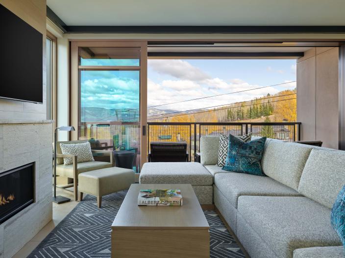 A room with an L-shaped couch and a fireplace at Viceroy Snowmass