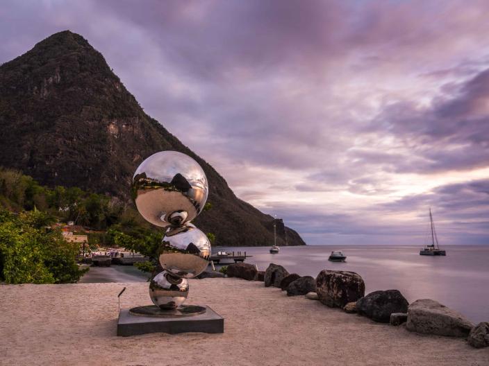 A sculpture consisting of three metallic balls, at the foot of the Pitons in Saint Lucia