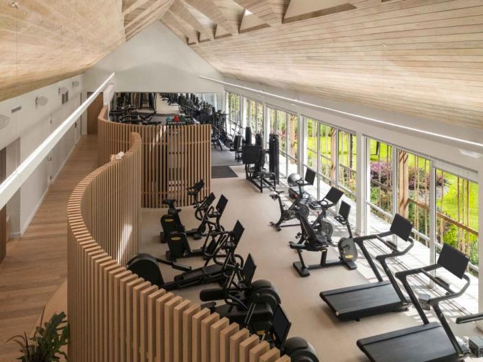 The fitness centre at Viceroy Sugar Beach, with a row of treadmills and exercise bikes looking out on a tropical landscape