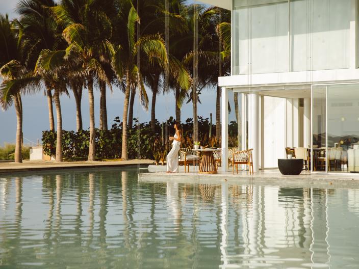 woman standing beside outdoor villa pool